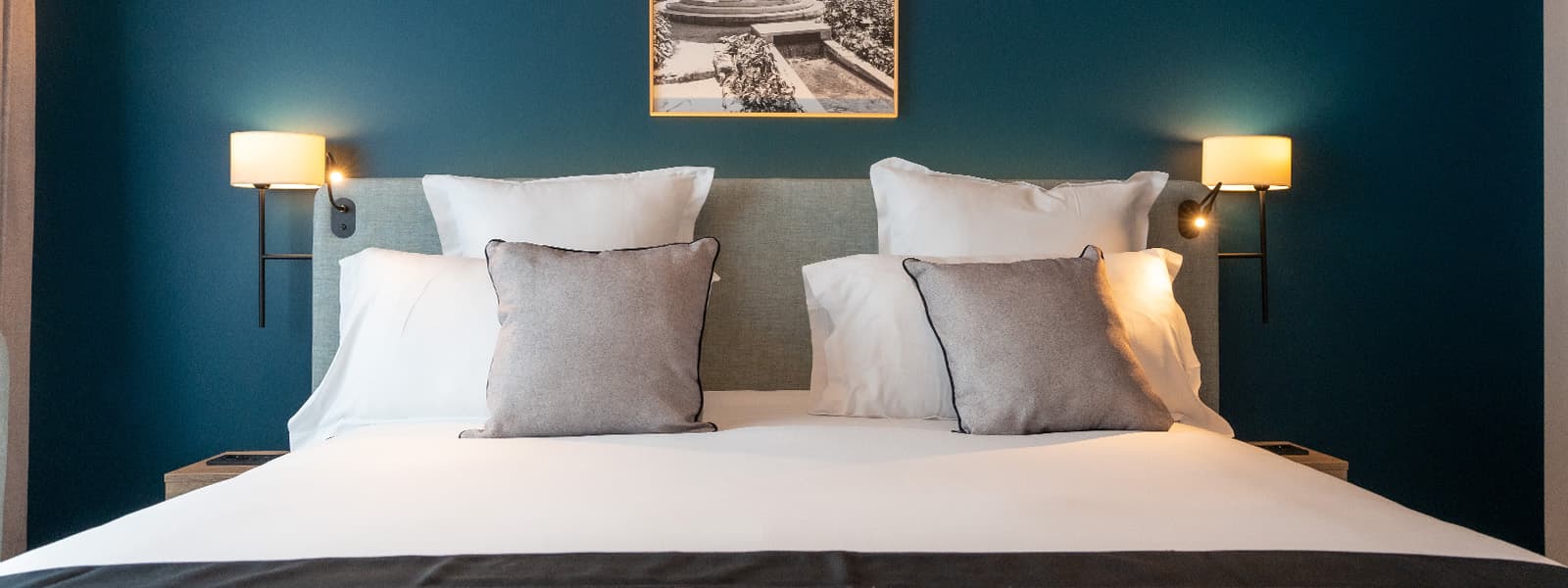 Chambre du Residhome Sénart, mur bleu pétrole et coussins gris